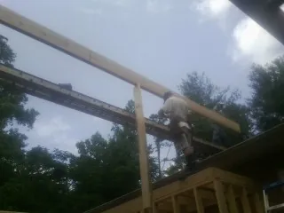 Carpenter setting a ridge beam over a new addition frame — Ice Dam Removal by Roofing Brothers in Bonlee