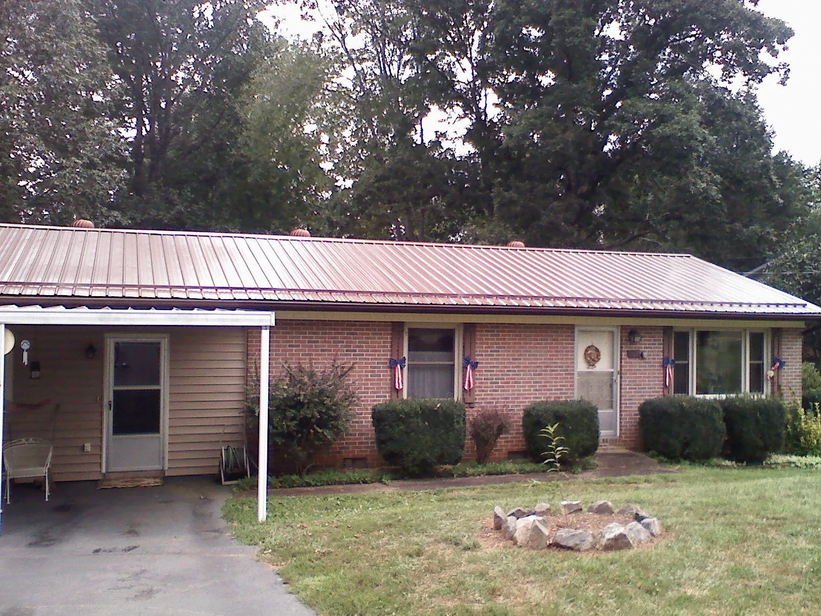 Bronze metal roof and carport on a brick ranch home — Roof Repair work by our crew in Bonlee